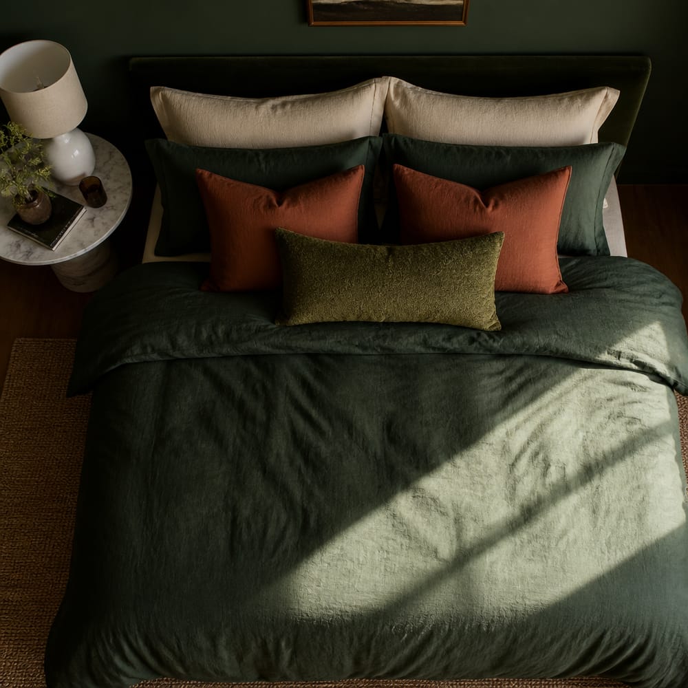 Vista superior de ropa de cama verde y óxido en capas