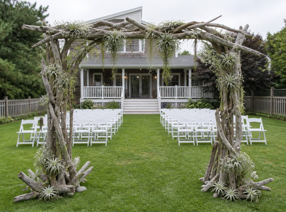 Driftwood boog met uitzicht op huis en zitplaatsen