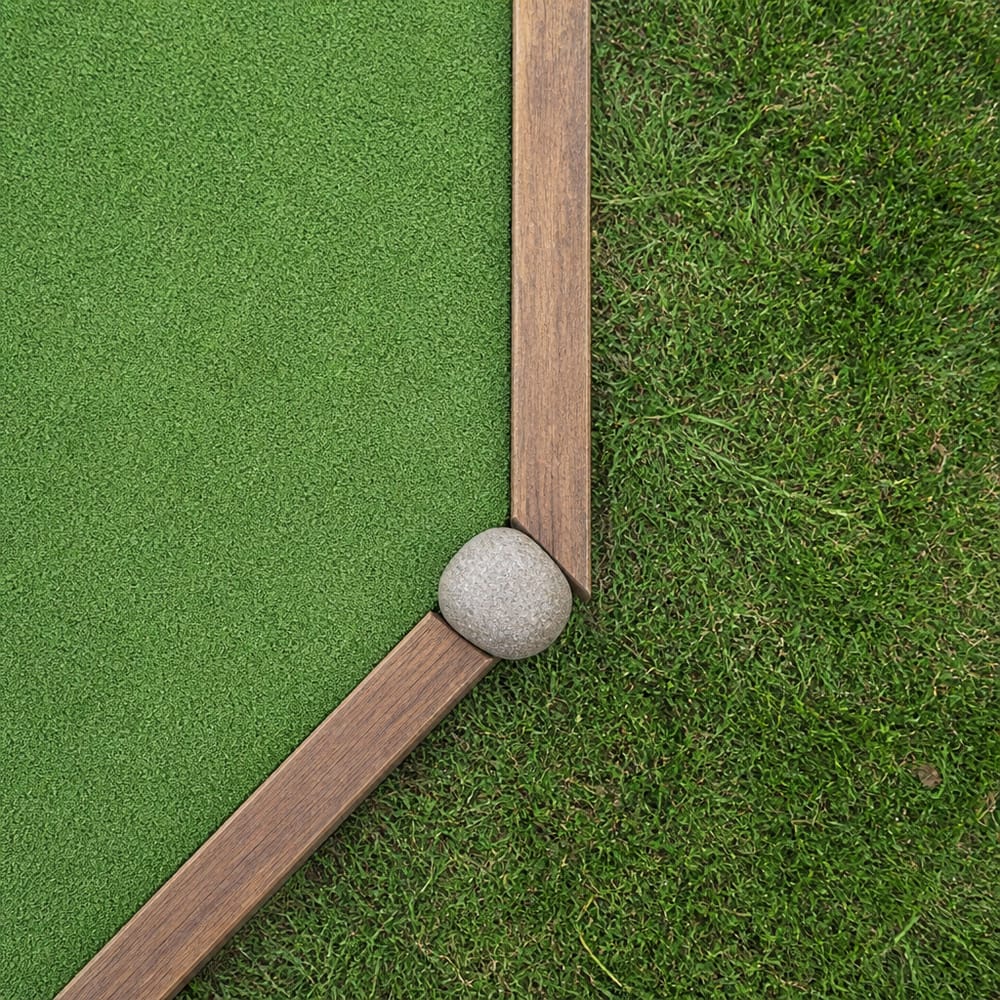 Houten hoekrand waar kunstgras het gazon raakt