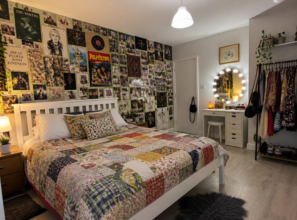 Muro con collage de pósters tras cama con colcha patchwork
