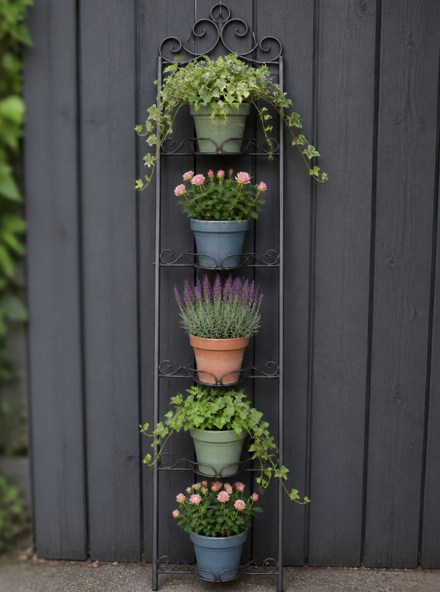 Escalera de jardineras de hierro forjado sobre cerca gris oscuro