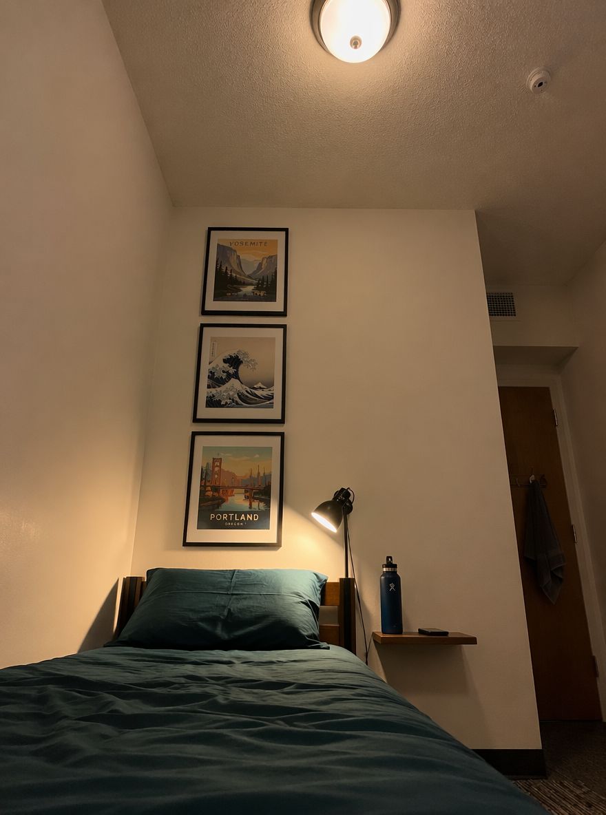 Vertikální galerie na stěně nad postelí, lampička na čtení s klipem