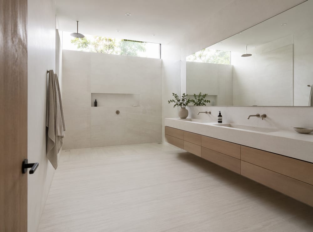 Lámina porcelánica casi continua en baño minimalista