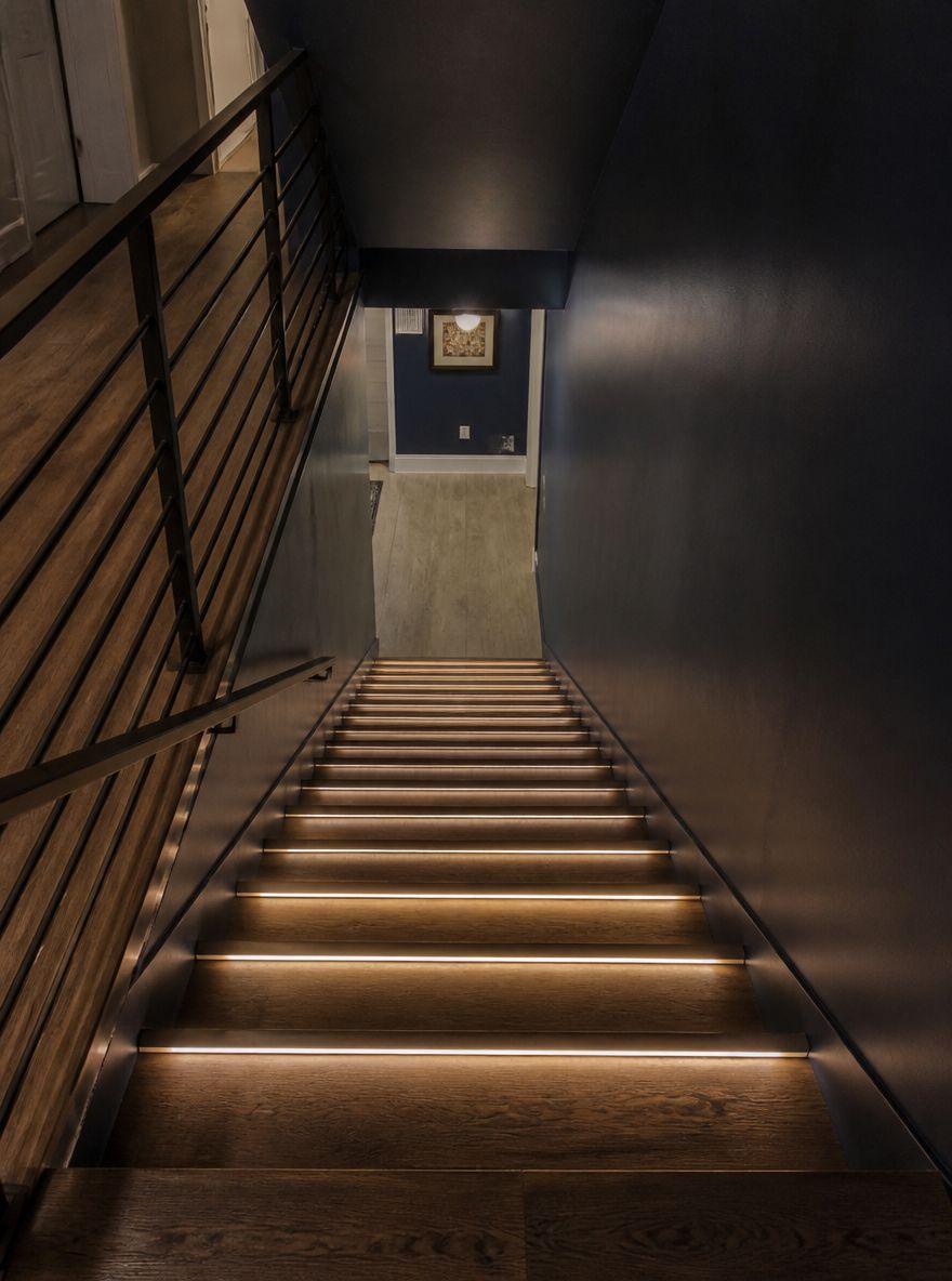 Tiras LED embebidas en peldaños de escaleras de nogal oscuro
