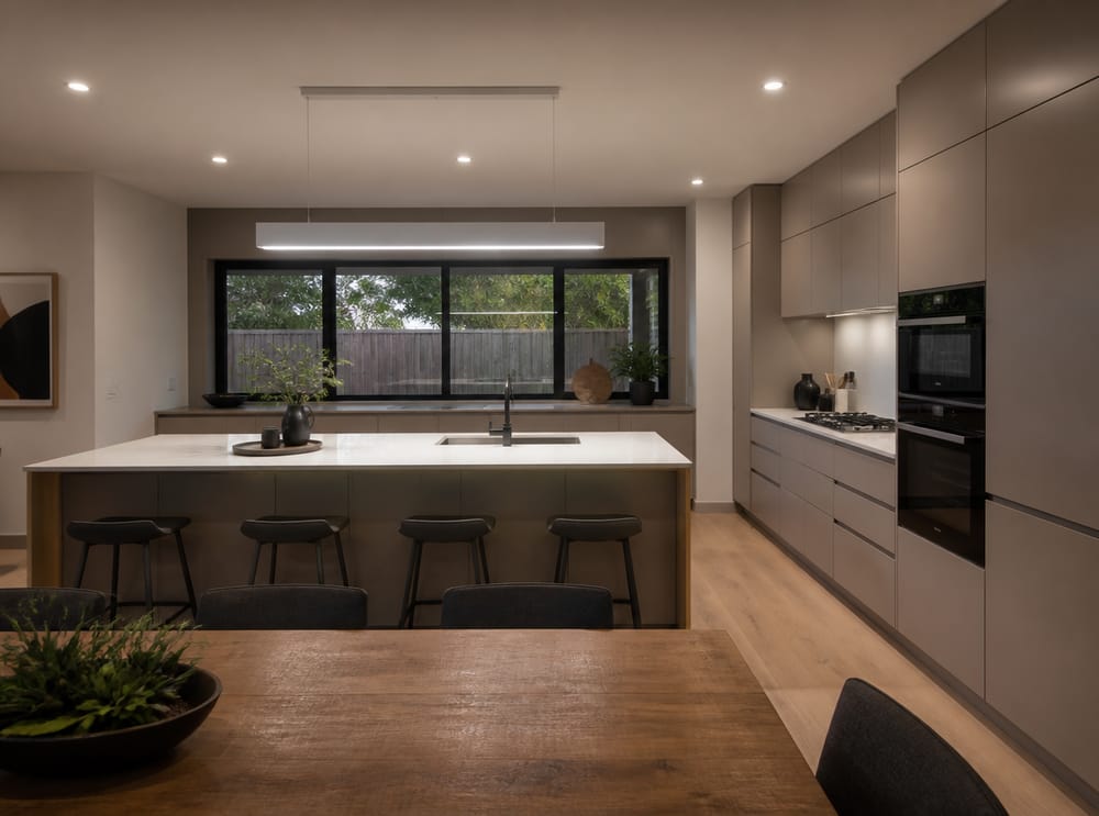 Panel LED flotante sobre cocina con isla greige y puertas planas