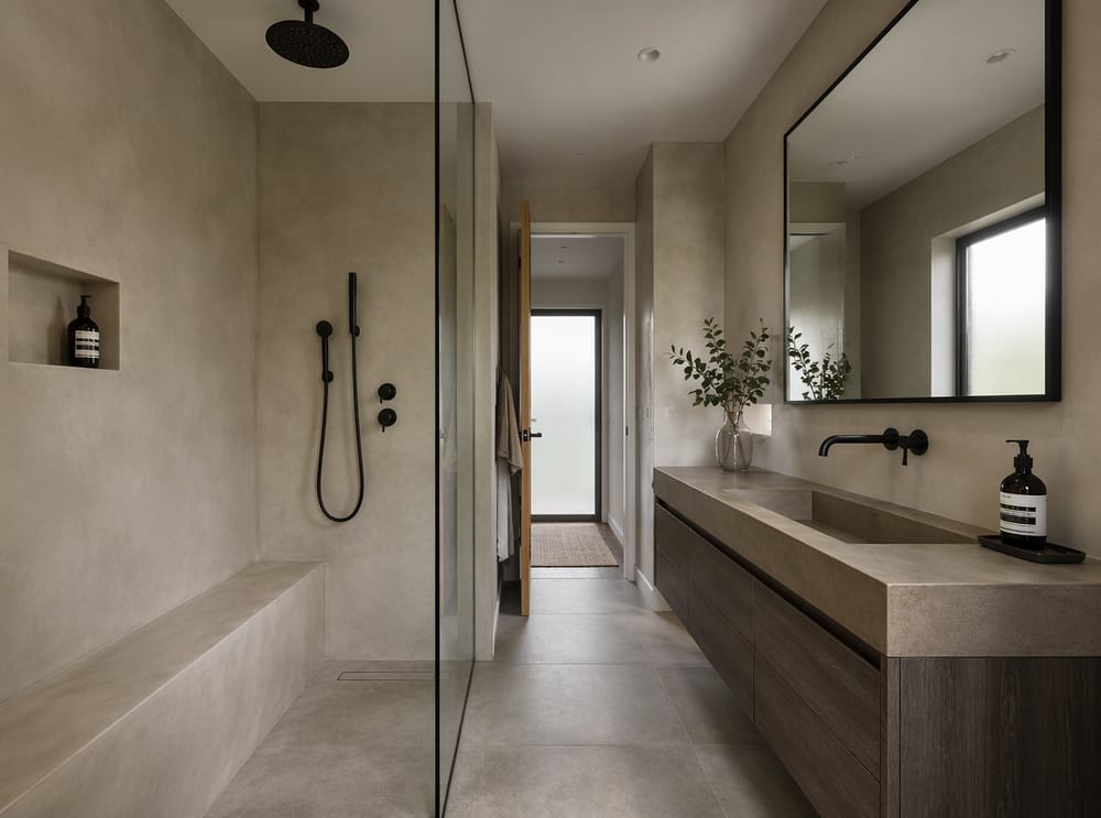 Doccia in microcemento accanto a mobile sospeso in rovere affumicato