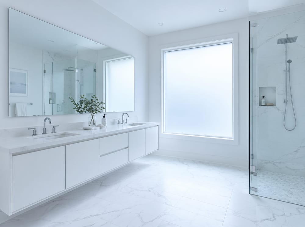 Luce fresca del mattino attraverso finestra satinata in bagno bianco