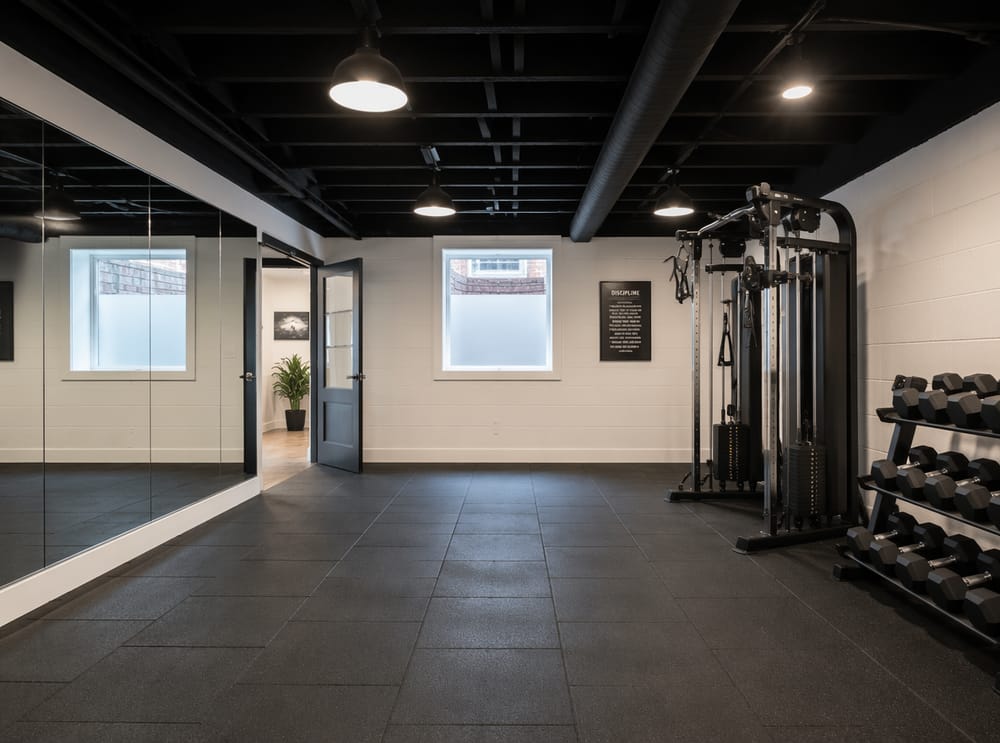 Palestra con pavimento in gomma e soffitto a vista verniciato di nero