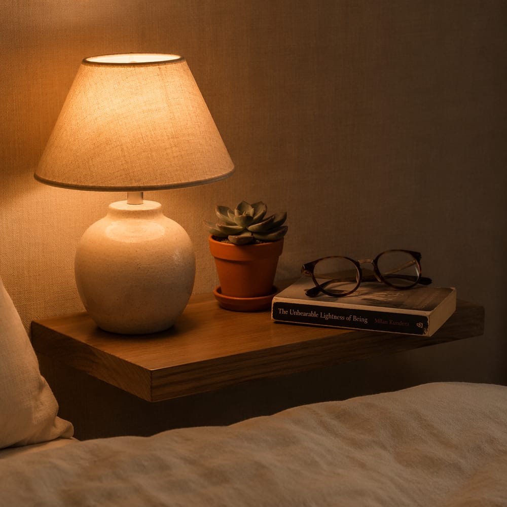 Keramikk-lampe og liten plante på flytende hylle