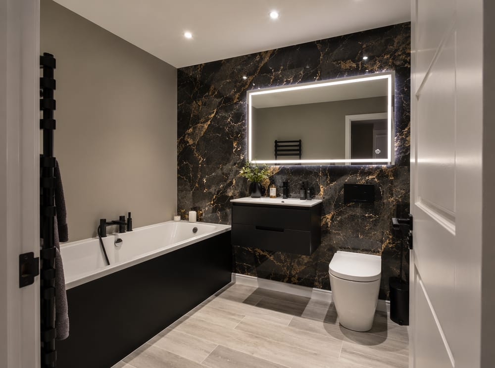 Pared destacada efecto mármol negro y dorado sobre bañera
