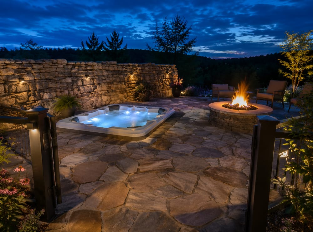 Flagstone terras, stenen privacy muur, aangrenzende vuurplaats