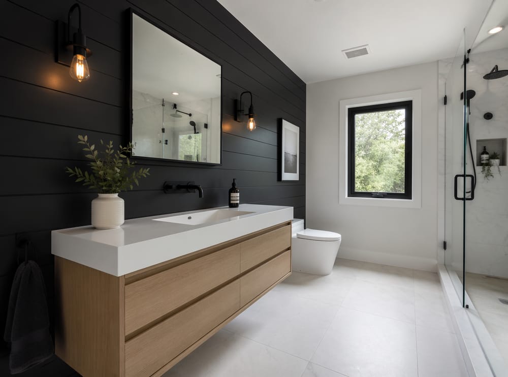 Pared decorativa de shiplap negro detrás de lavabo blanco suspendido
