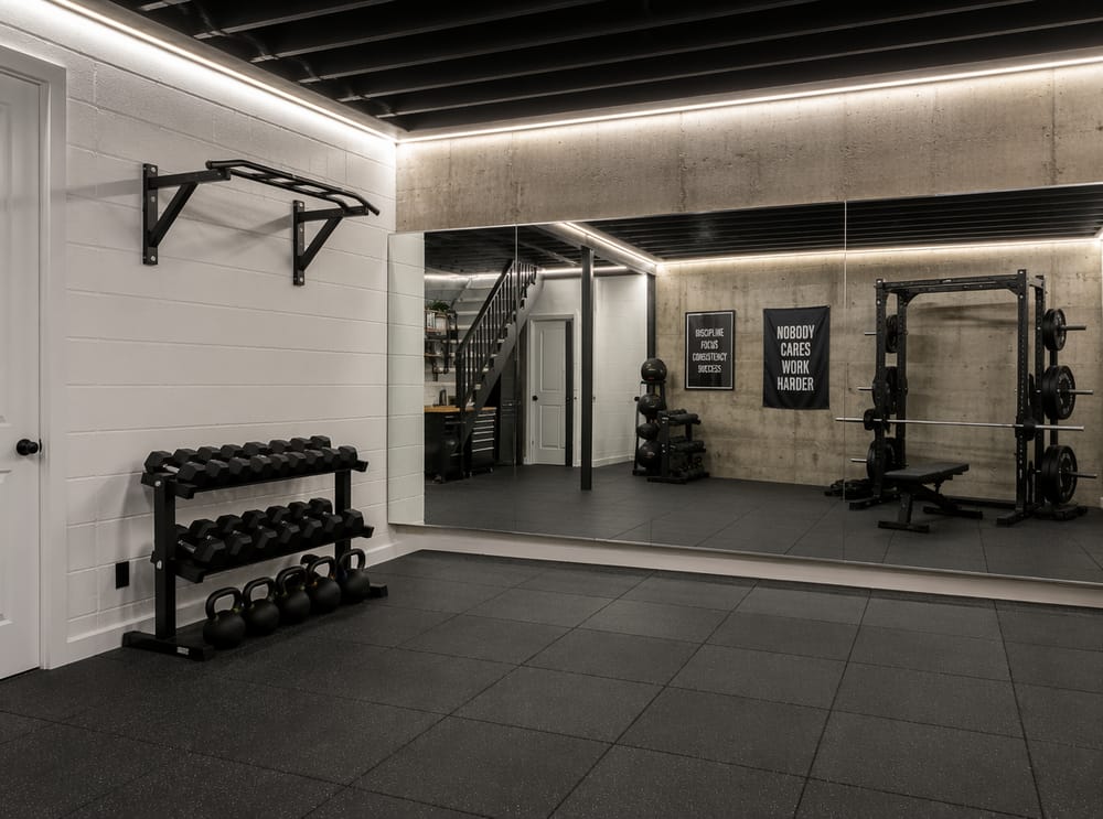 Espejos de piso a techo en la pared de ejercicio del gimnasio en sótano
