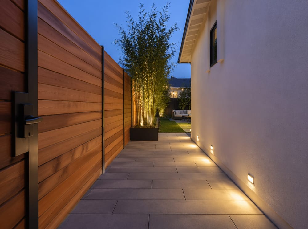 Passage en béton éclairé menant au jardin principal